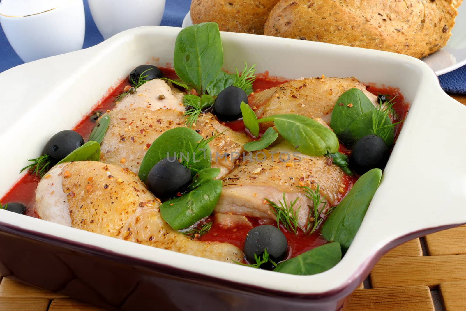 Pieces of chicken in tomato sauce with olives and spinach