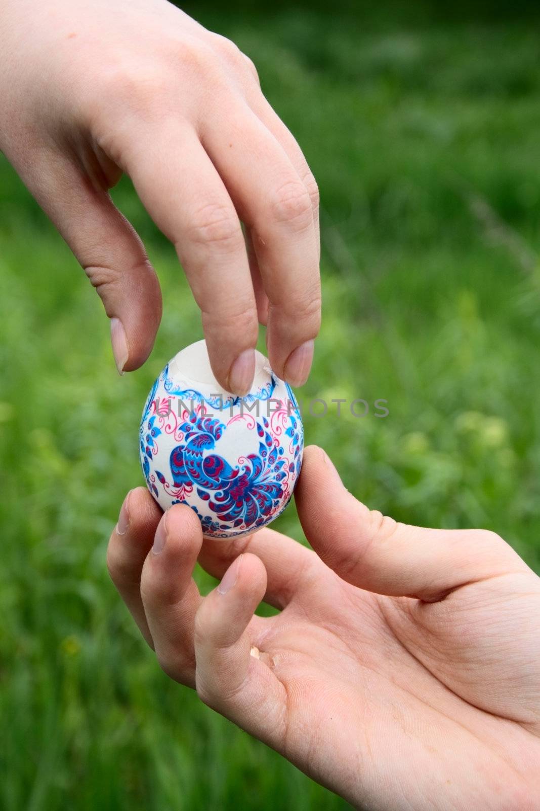 male hand giving easter color egg to woman hand