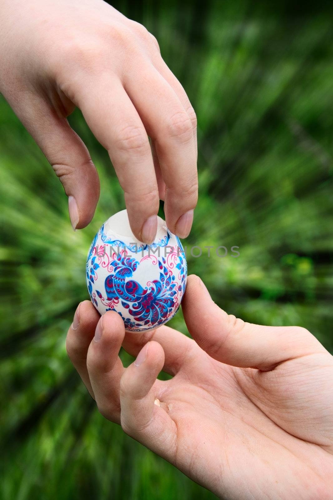 male hand giving easter color egg to woman hand