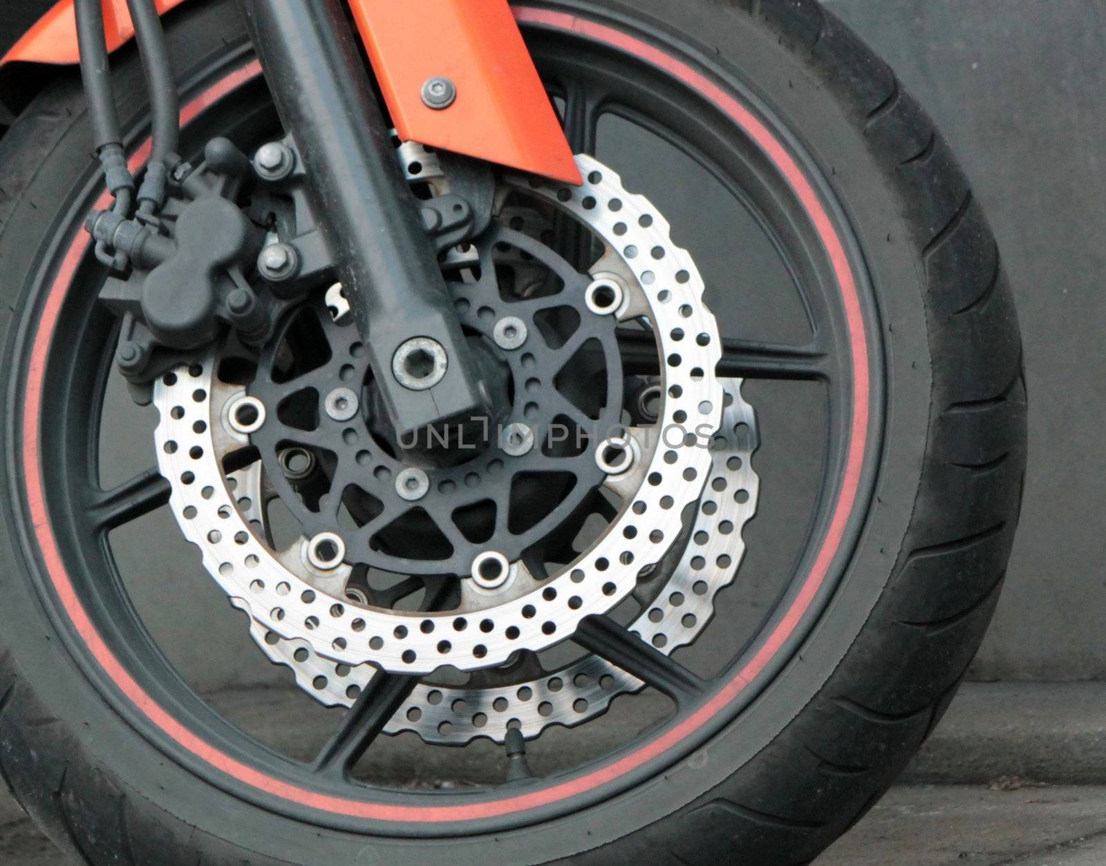 Close up of the front wheel of a red motorbike