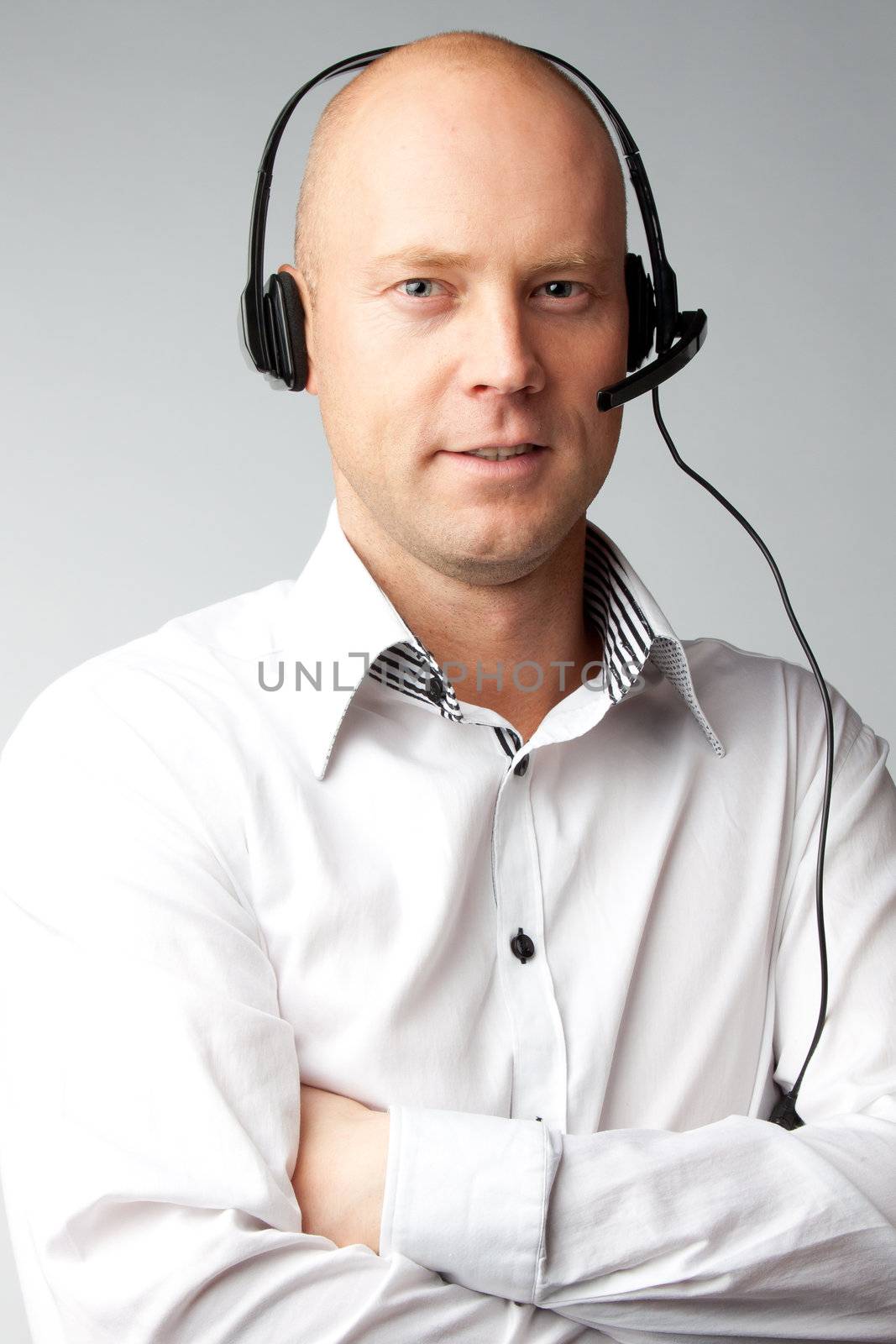 Portrait of a young handsome man with a headset on his head, who works in customer service