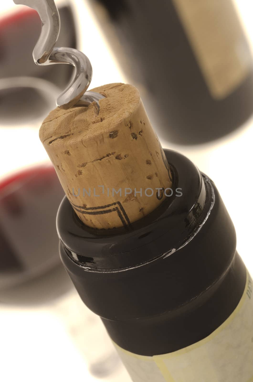 Opening a wine bottle and two wine glasses at background.(Shallow DOF)