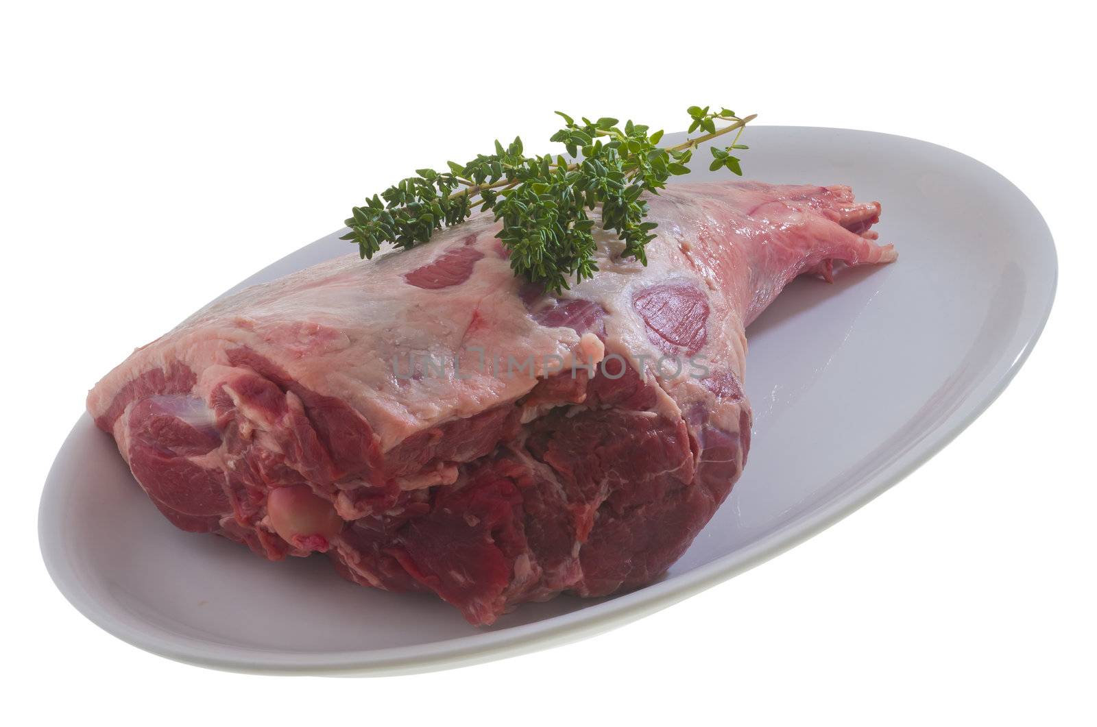 Raw leg of lamb with thyme on a white dish