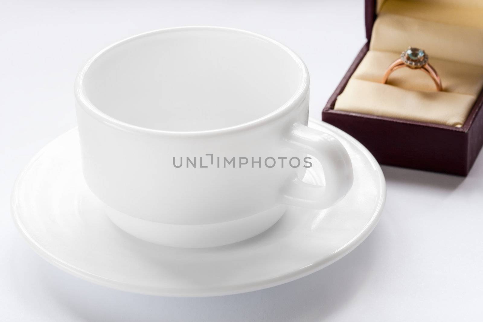 gold ring with a diamond and a cup and saucer
