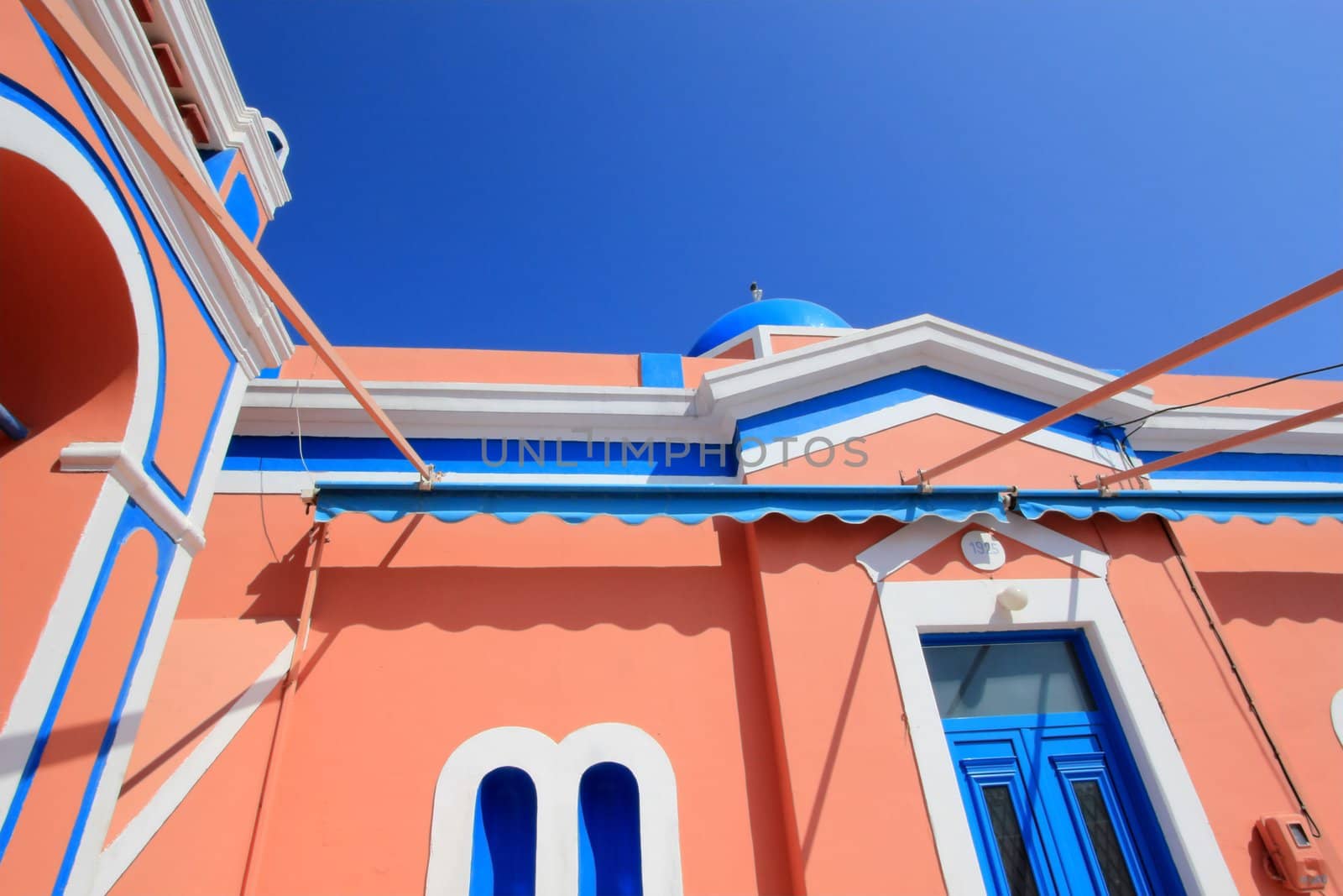 Close up of colorful orthodox church with typical architecture and blue dome in Oia, Santorini island, Greece
