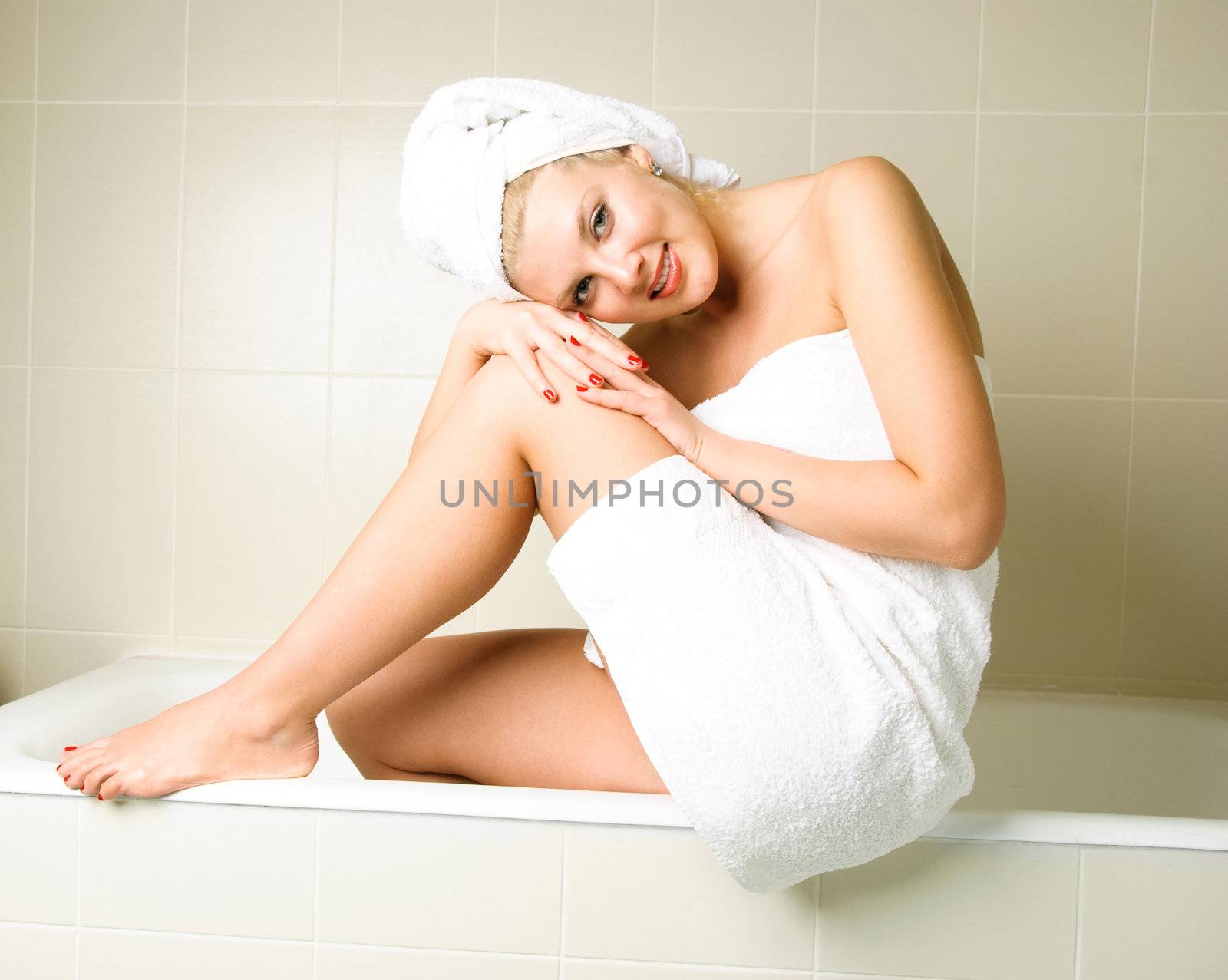 beautiful young woman wrapped into white towels in the bathroom