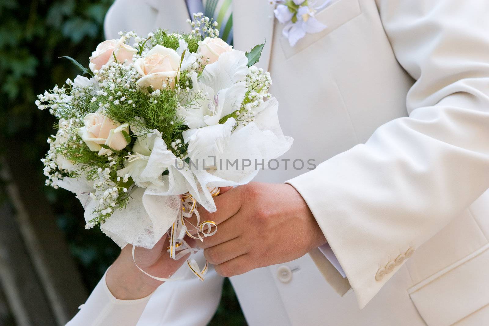 wedding bouquet in hands of bride and  groom