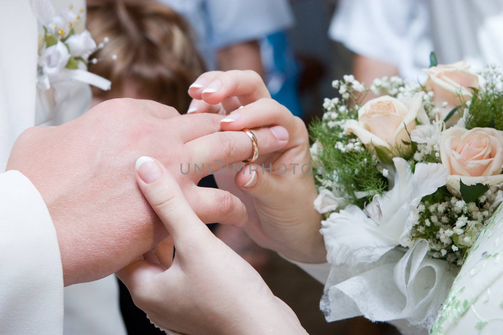 bride puts on a wedding ring to a groom