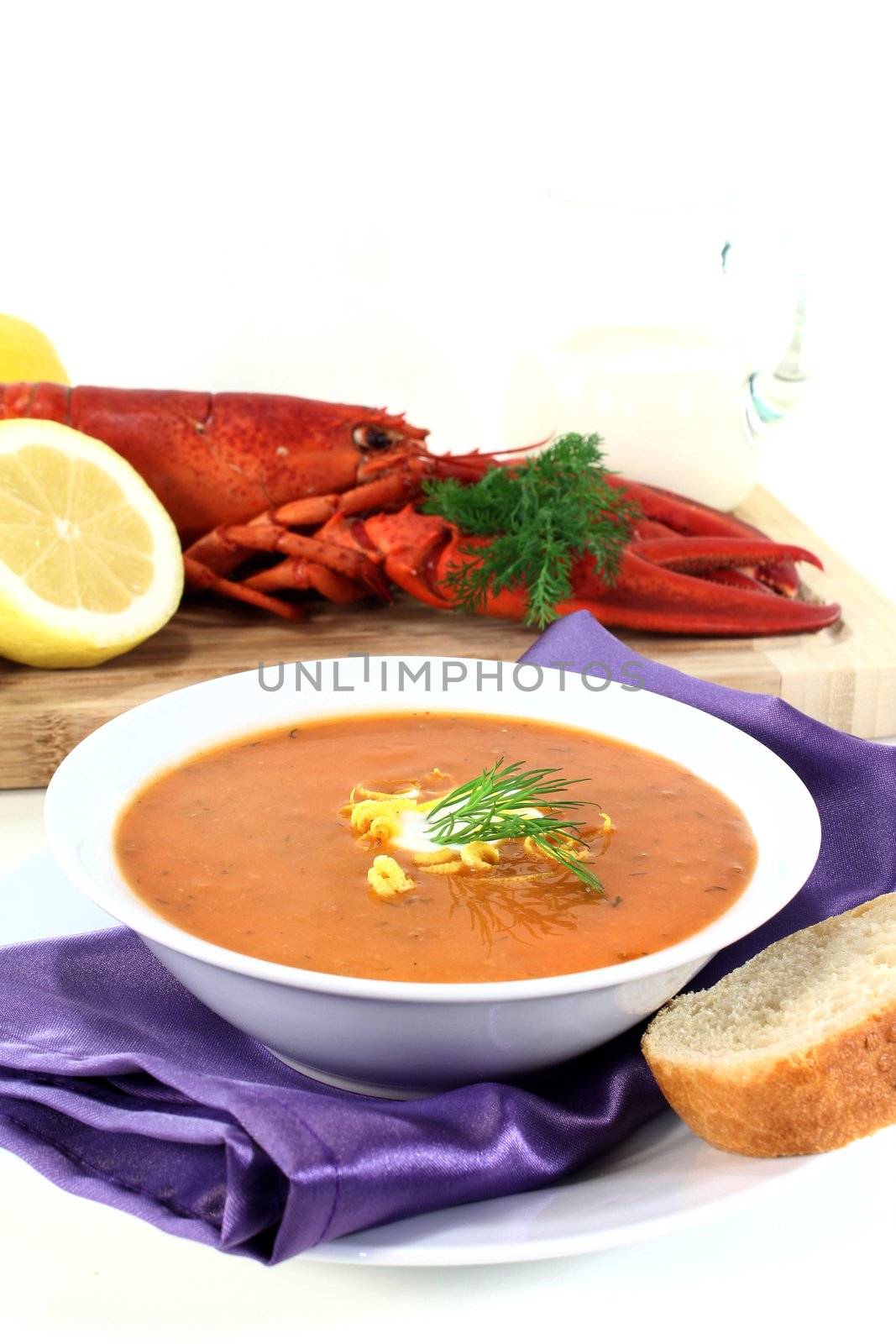 a bowl of lobster soup with dill and lemon