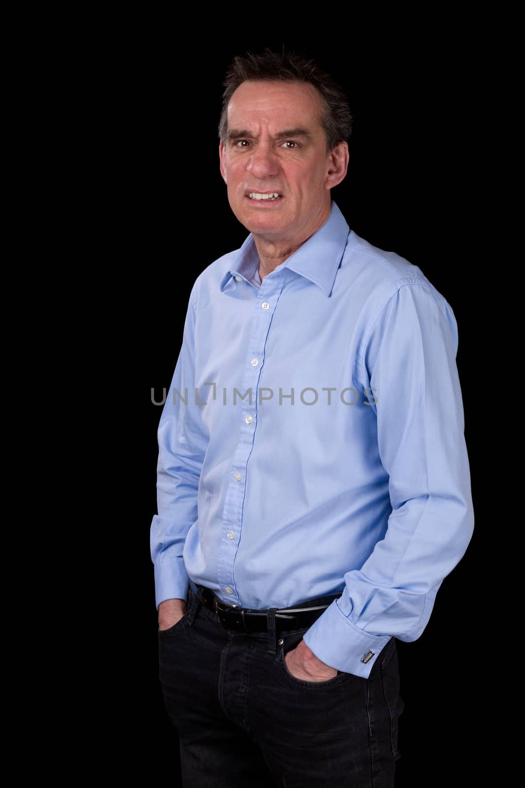 Angry Frowning Scowling Middle Age Business Man Hands in Pockets Black Background
