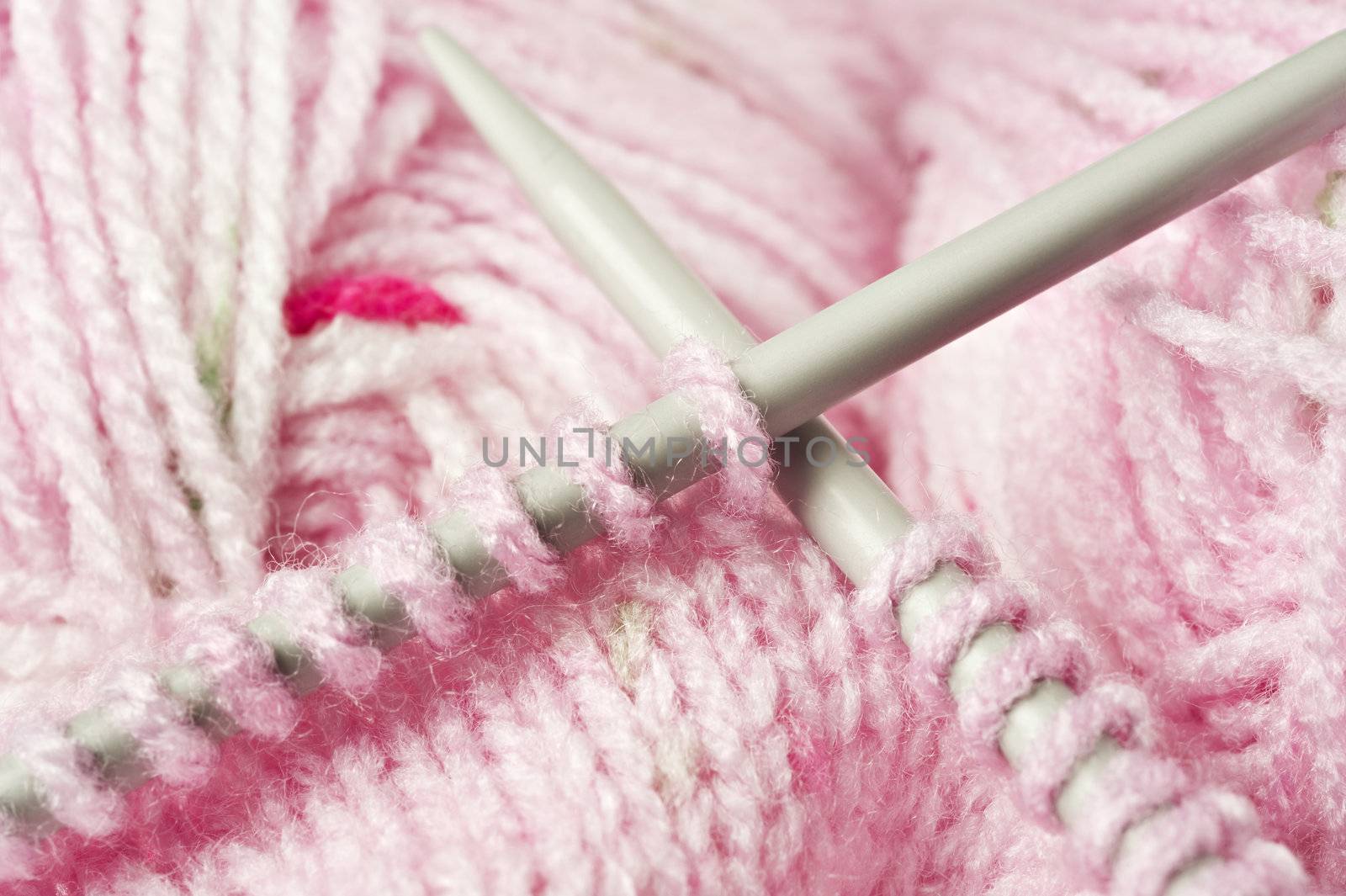 Knitting a pink baby jersey - yarn and pens