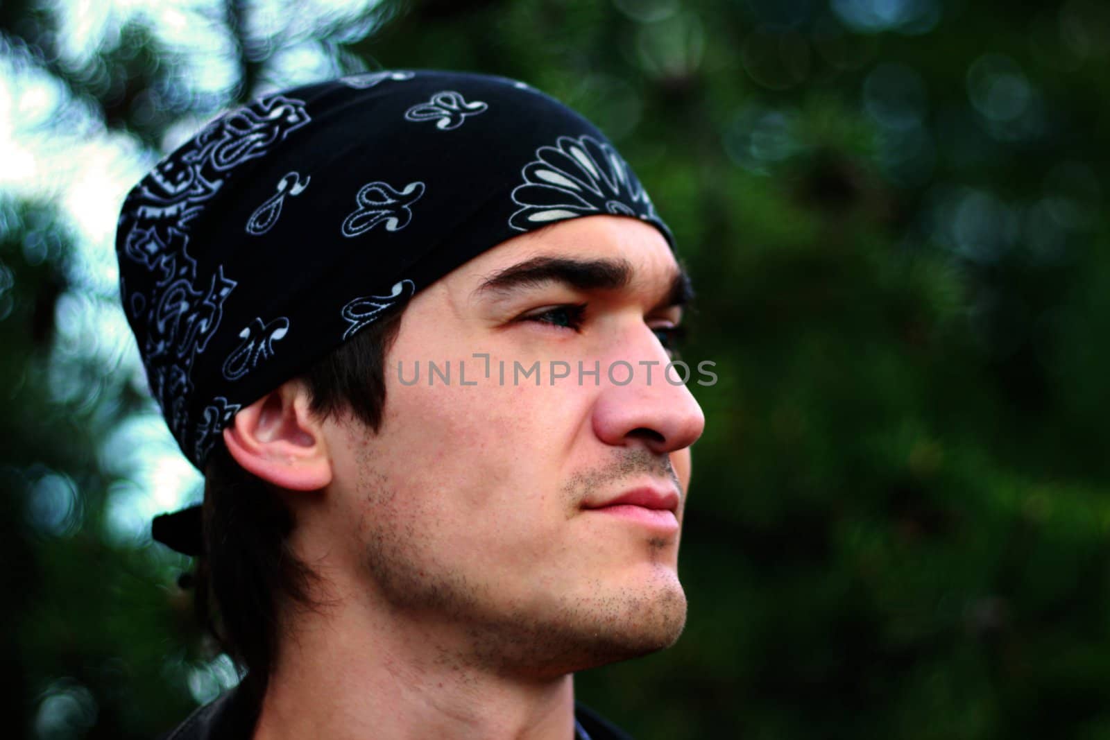 A handsome man in a bandana and a leather jacket in black with a hand from a person in joyful meditations