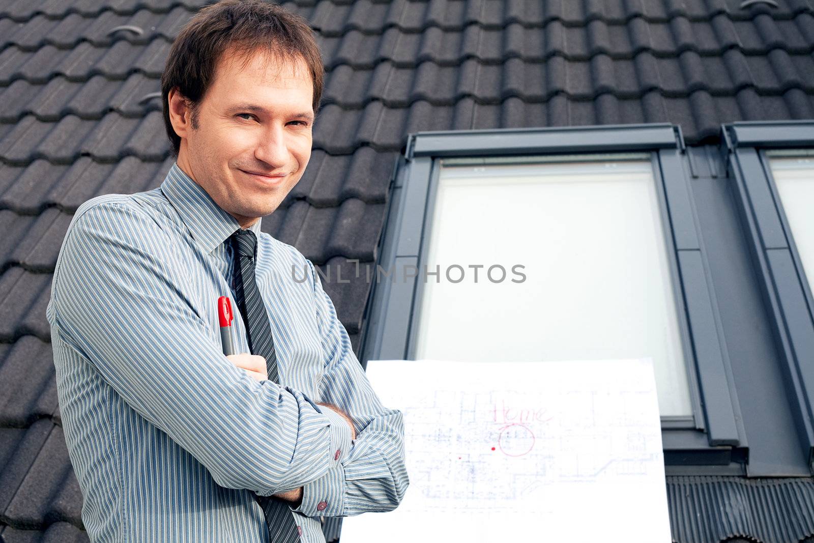 young man architect presenting a project against the background of the roof and windows