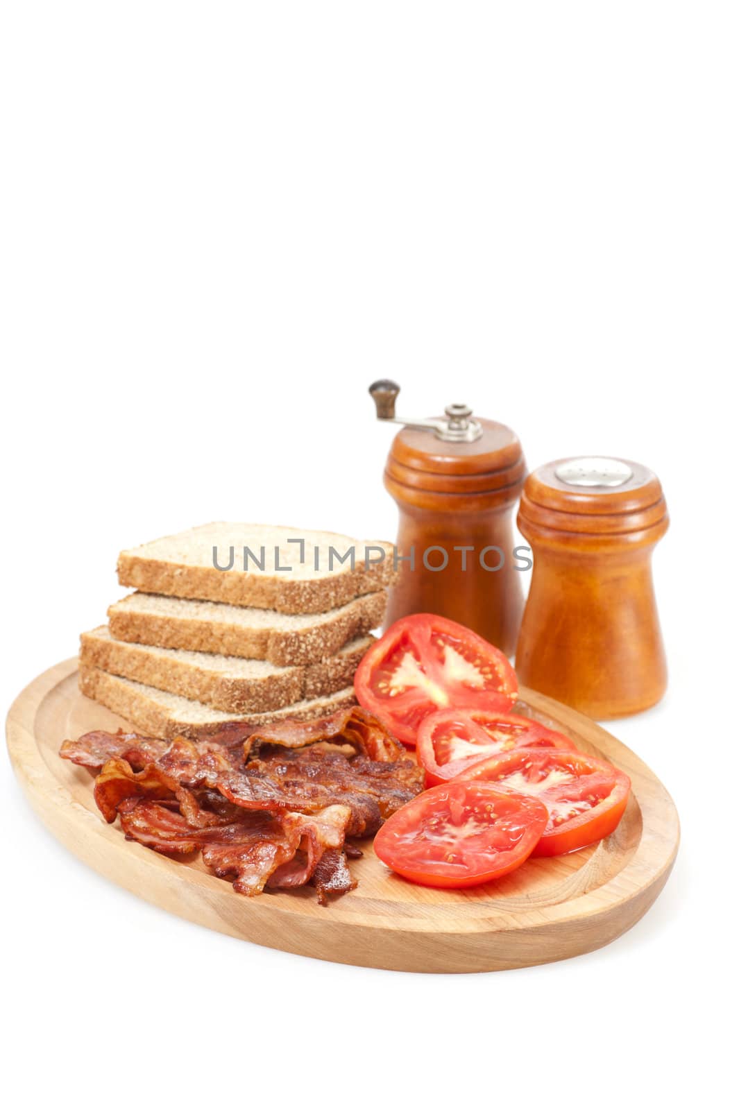 Platter of cooked bacon and fresh tomatoes on a white background.