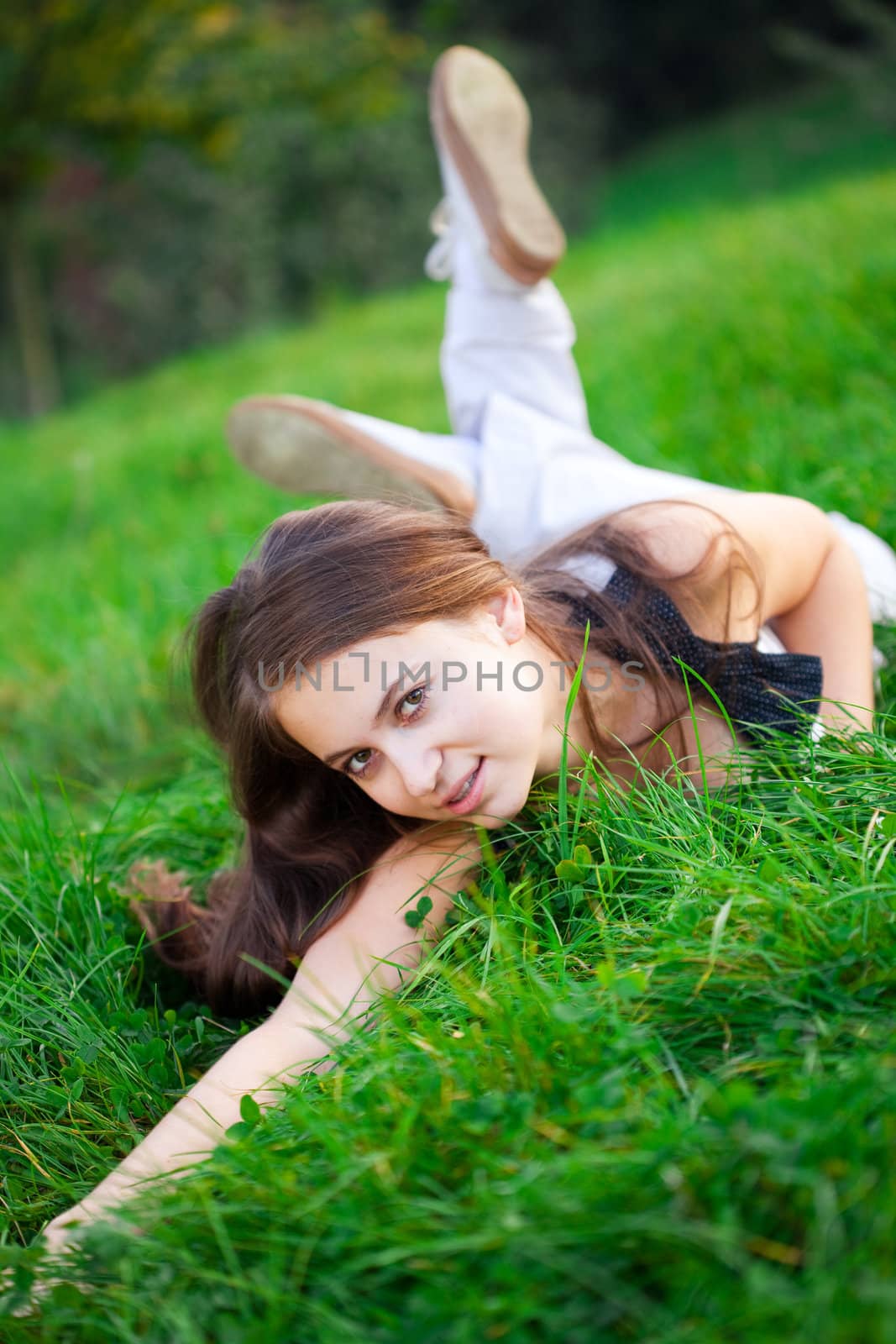 beautiful young woman lying on green grass