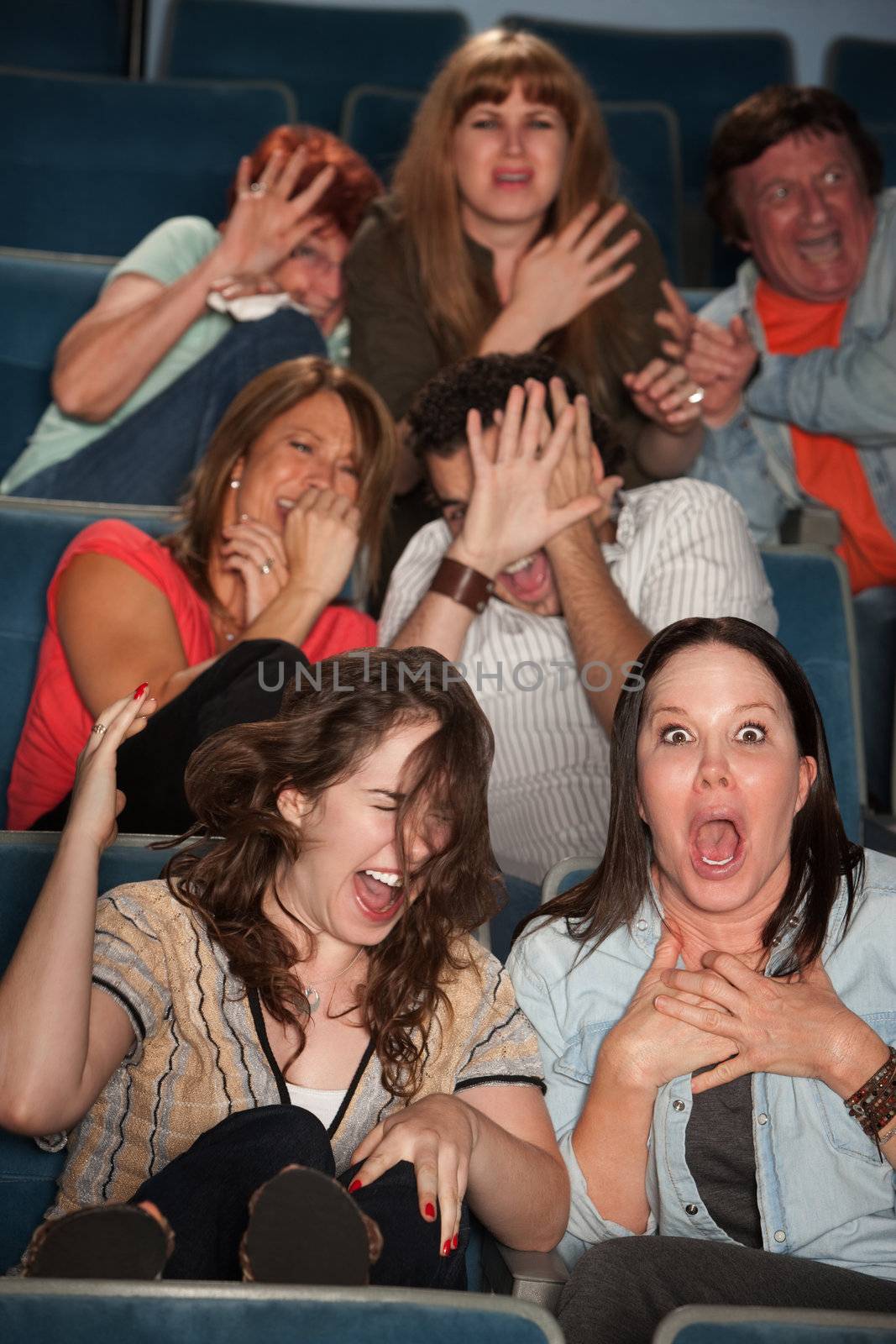 Group of seven scared audience members cringe in their seats