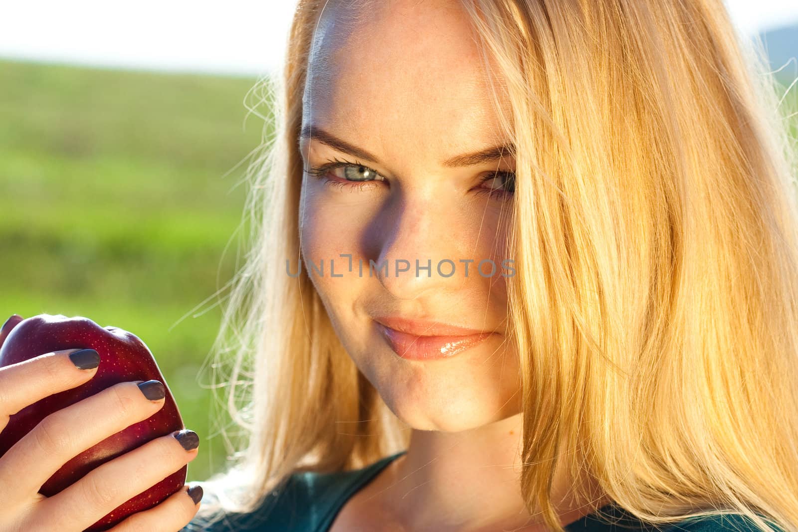 portrait of a beautiful young woman with apple  outdoor