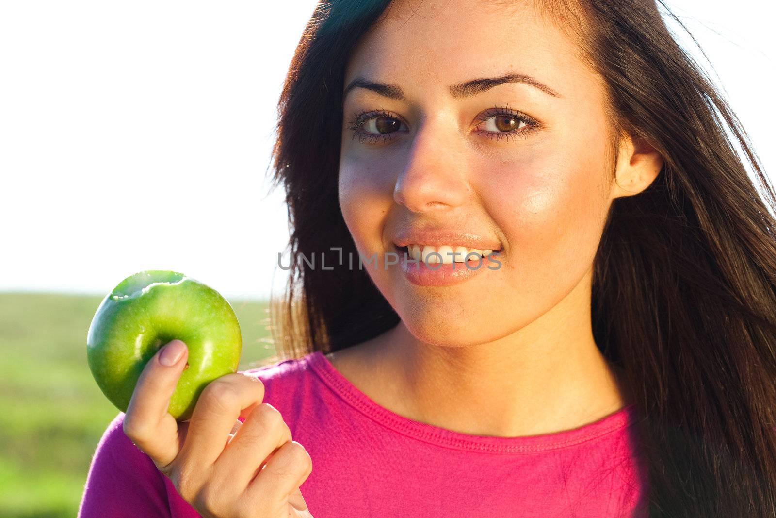 portrait of a beautiful young woman with apple  outdoor