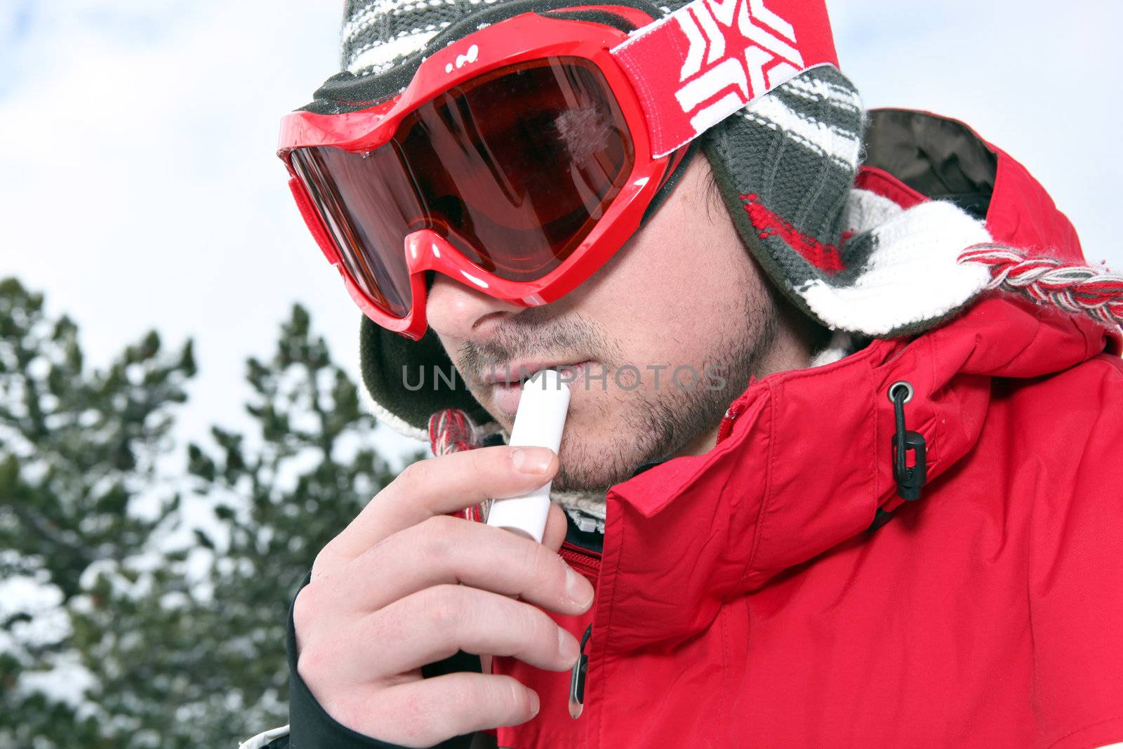 Skier applying lip balm by phovoir