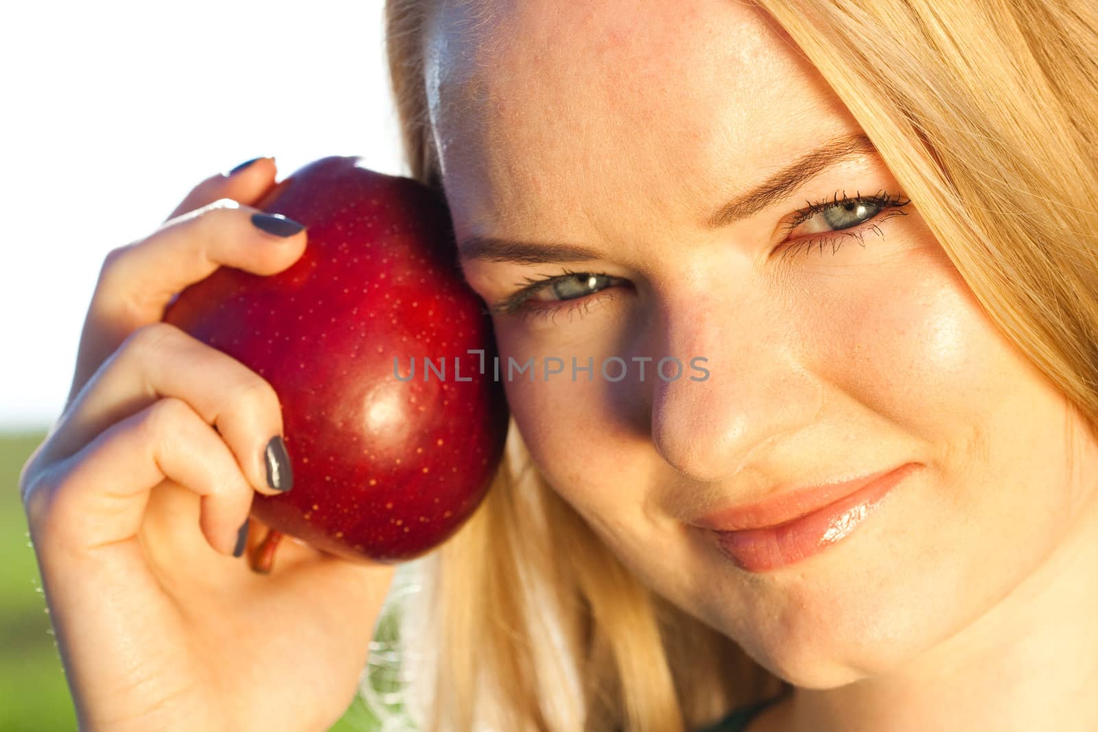 portrait of a beautiful young woman with apple  outdoor