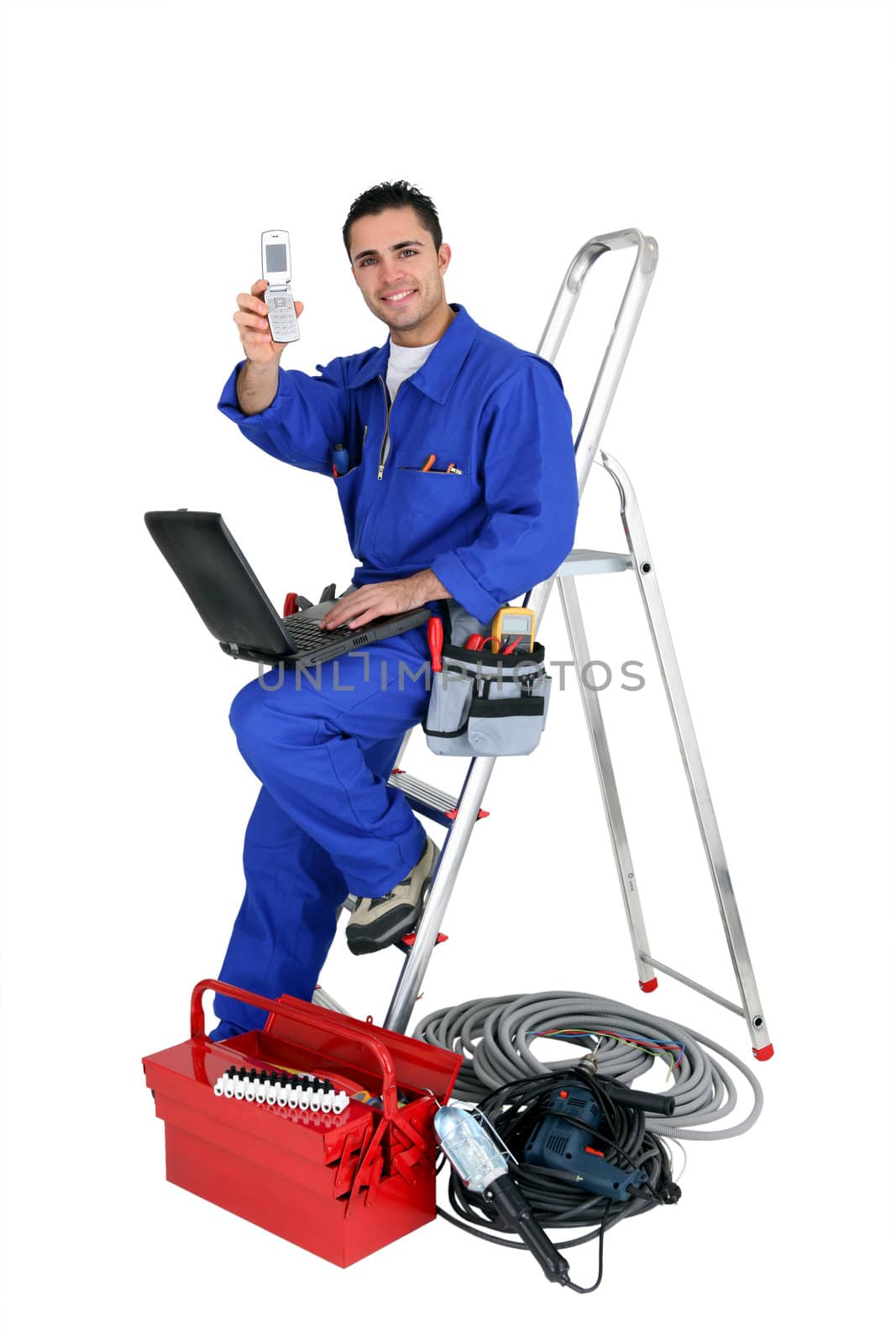 Technician with laptop and cellphone leaning on a ladder