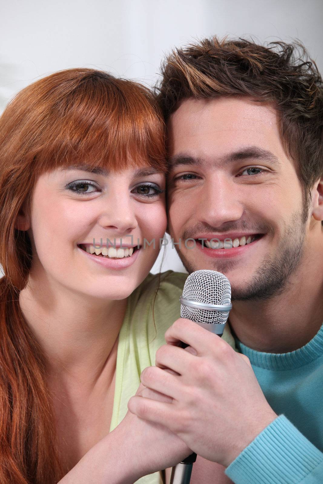 Young couple with a microphone by phovoir