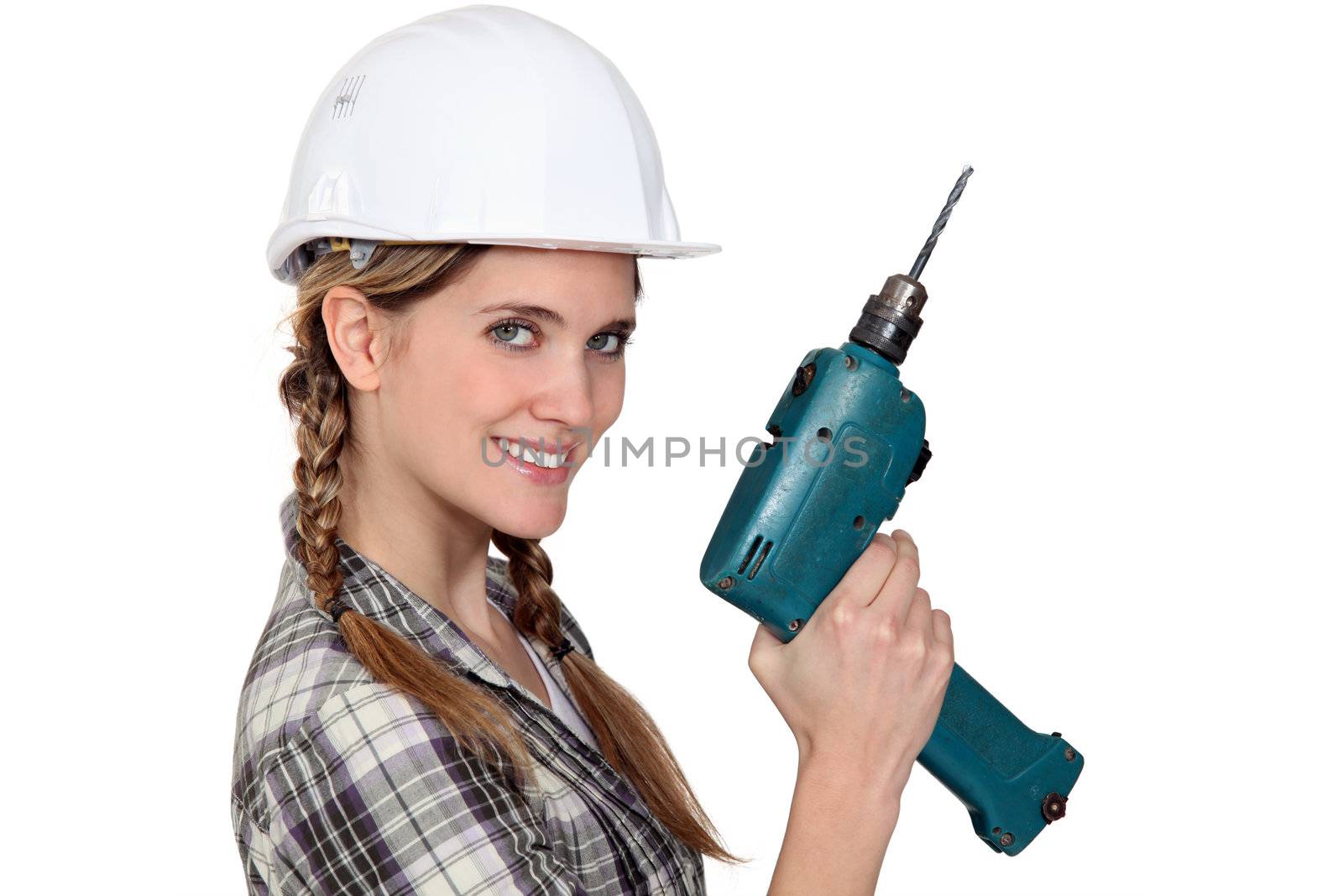 Smiling tradeswoman holding a power tool by phovoir