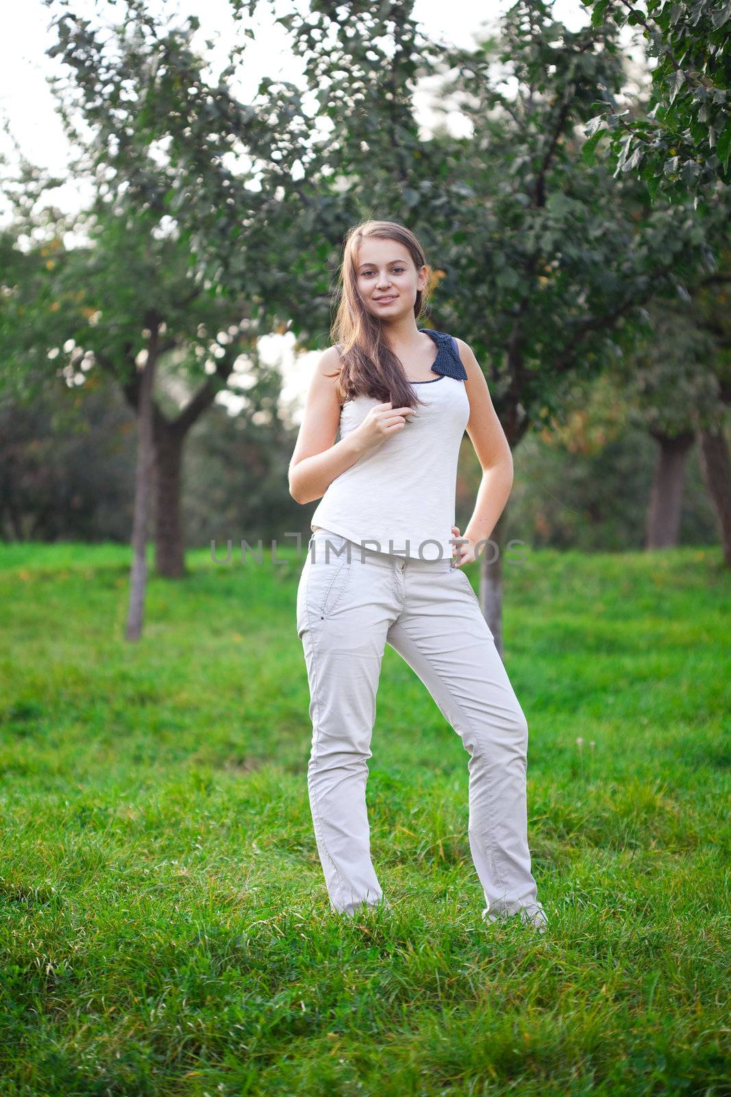 beautiful young woman standing on green grass