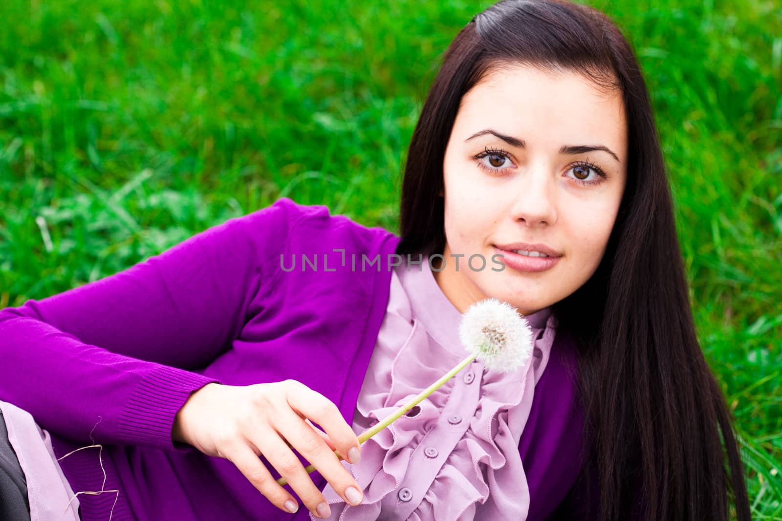 portrait of a beautiful young woman with dandelion