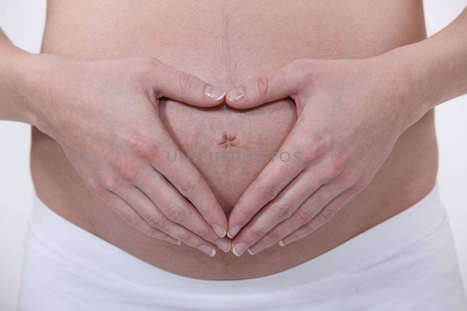 Pregnant woman making a heart shape on her stomach