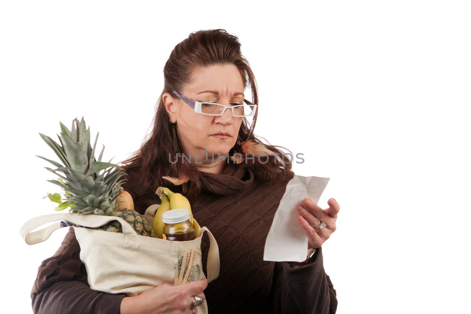 Middle aged woman carefully examining her register receipt reviewing her grocery shopping bill.