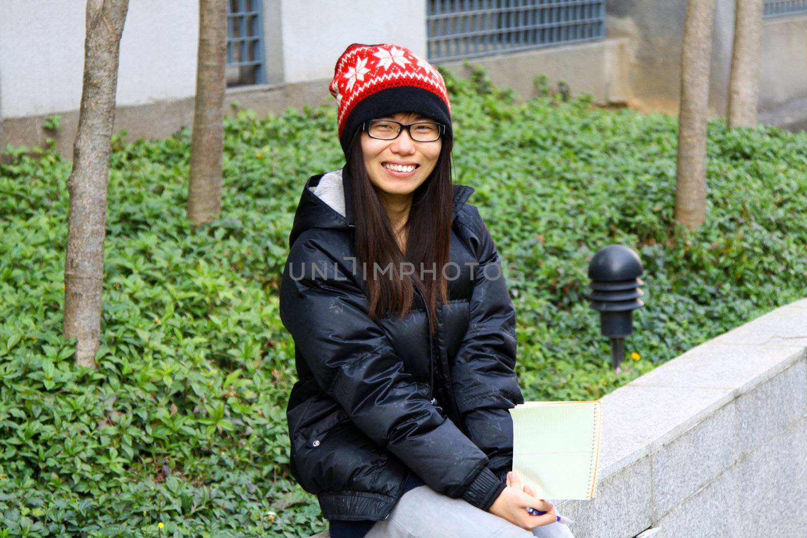 Asian student smiling on campus by kawing921