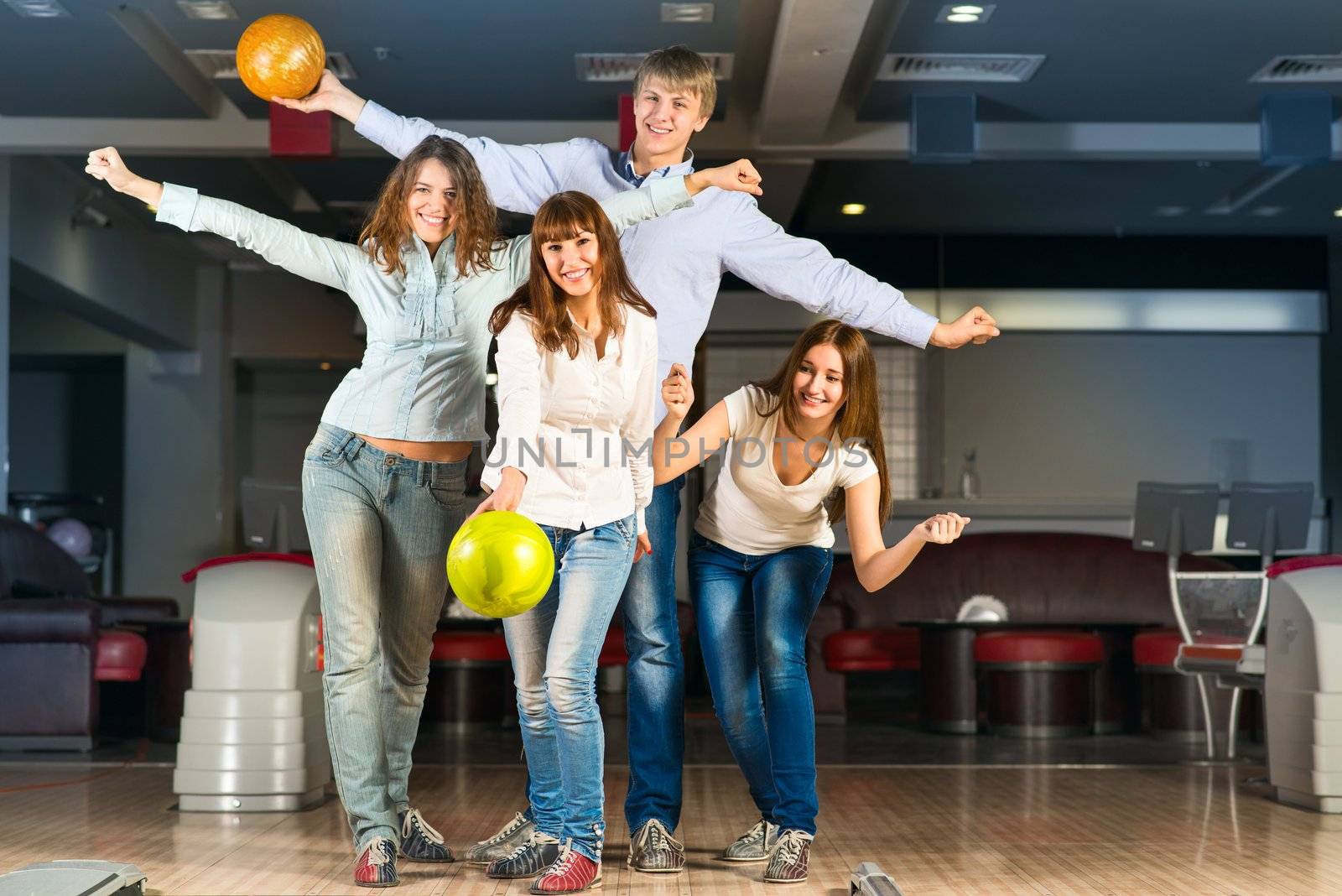 Group of young friends playing bowling, spending time with friends