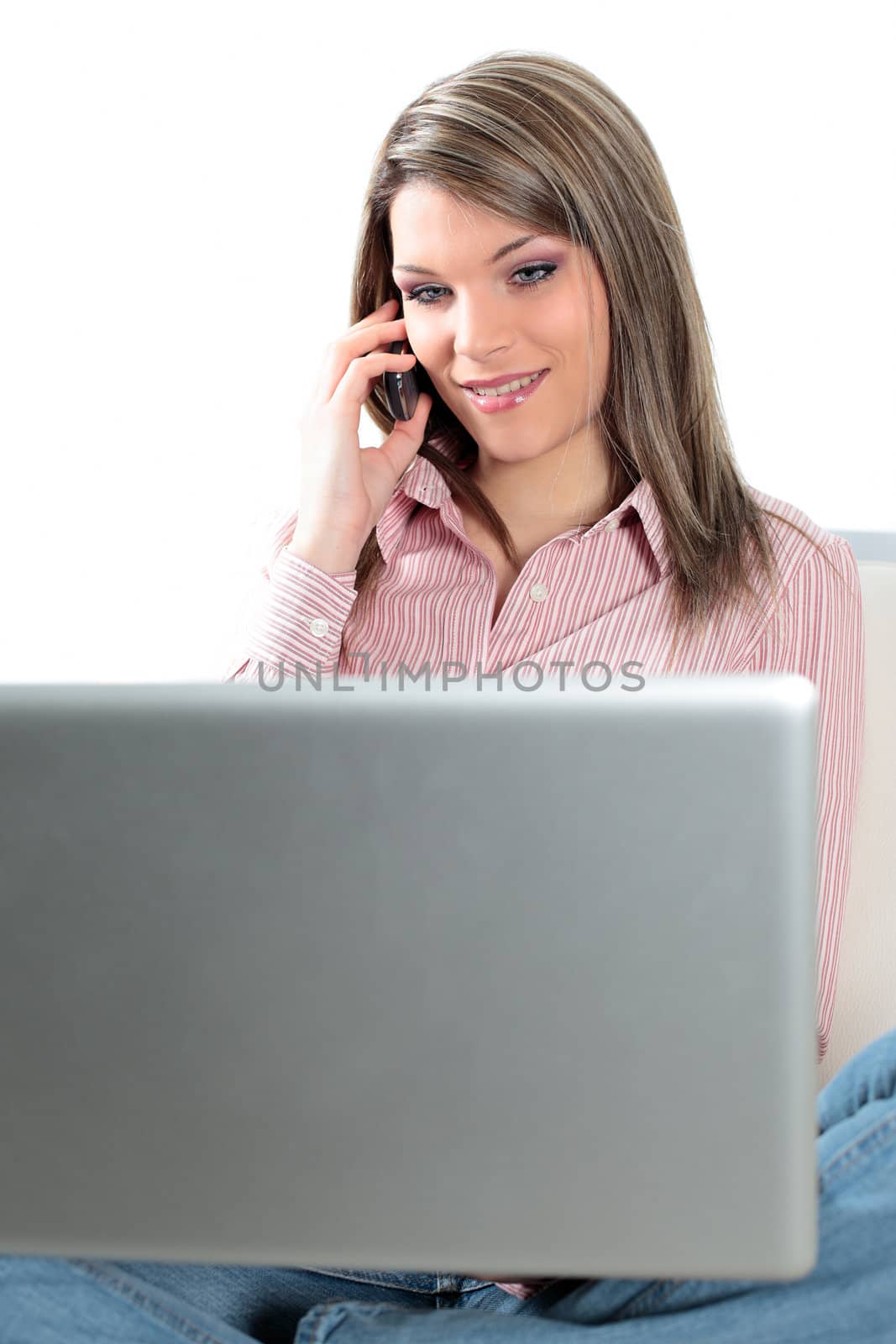 beautiful blond woman on sofa with laptop and phone