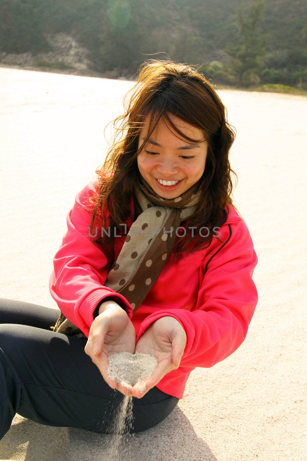 Woman using sand to make heart by her hands  by kawing921