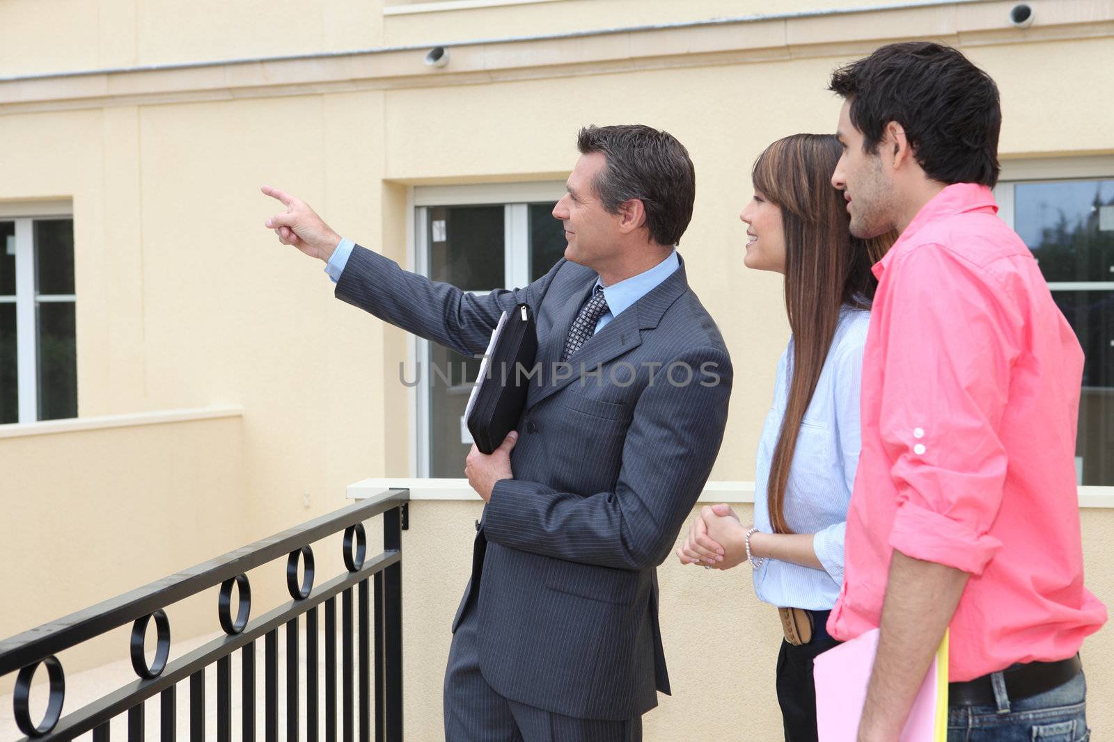 couple and realtor showing property