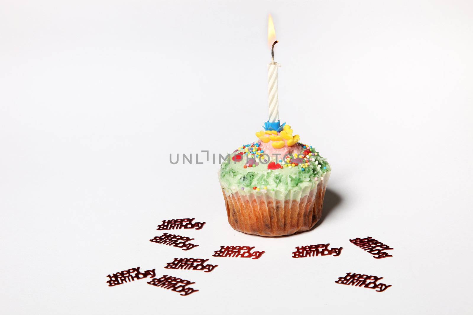 Sweet cupcake with a candle and Happy Birthday lettering