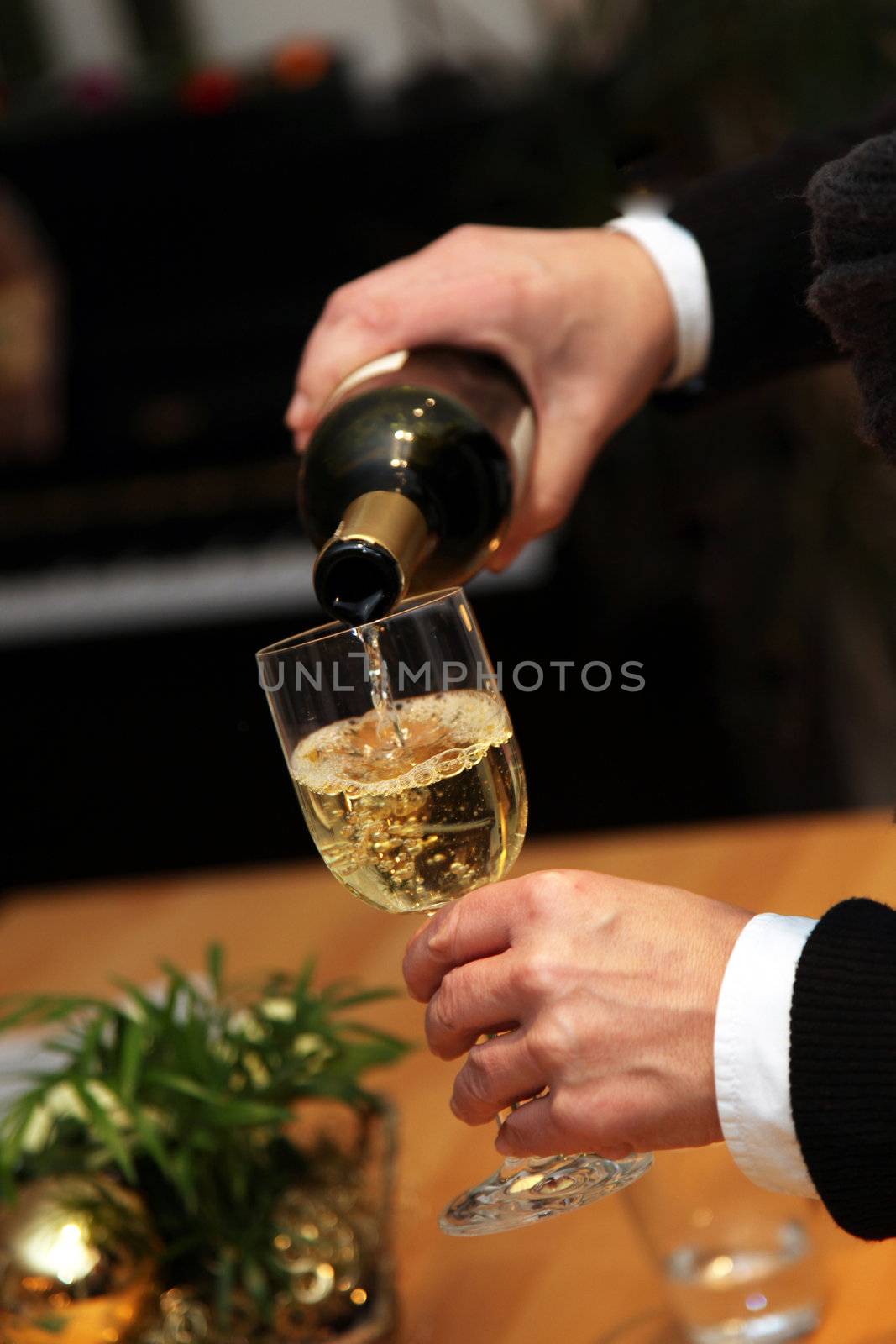 Waiter pours a glass of wine