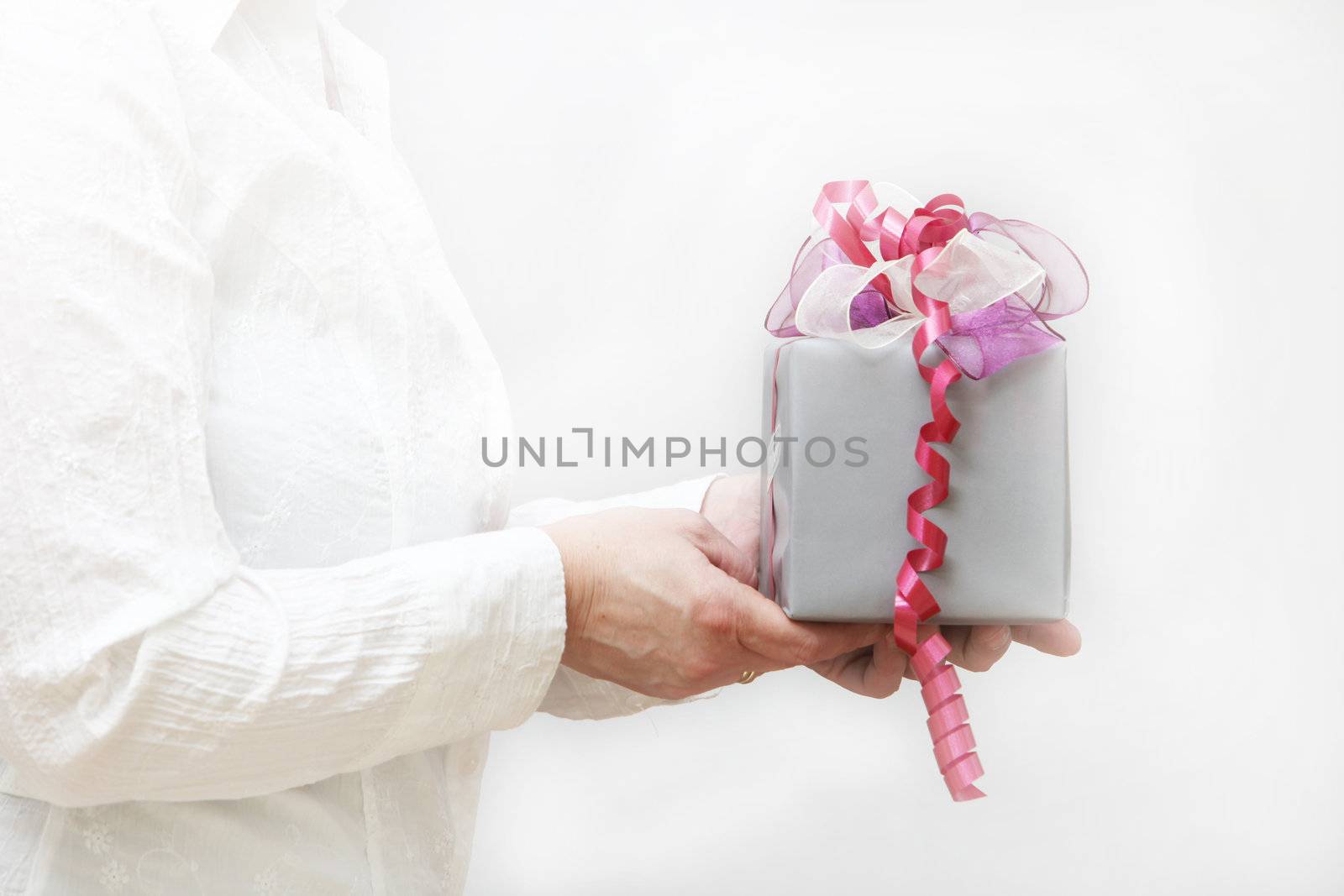 Nice gift with bow is held by women, against a white background