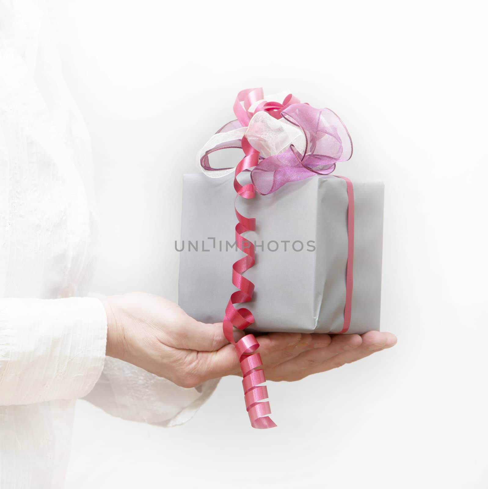 Woman presented with a gift ribbon - white background
