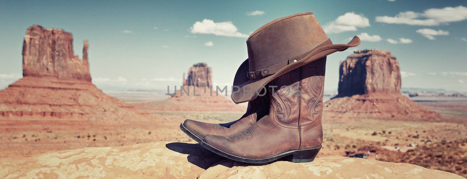 boots and hat in front of Monument Valley, USA, panoramic view