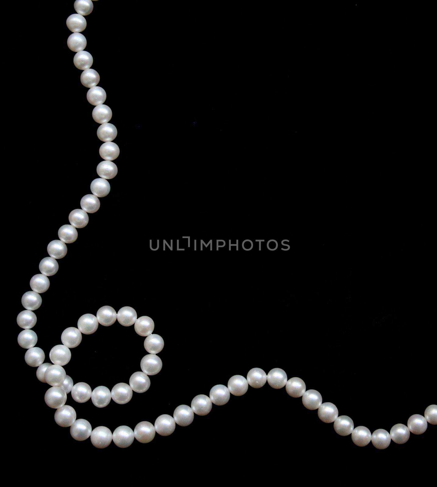 White pearls on the black velvet background 