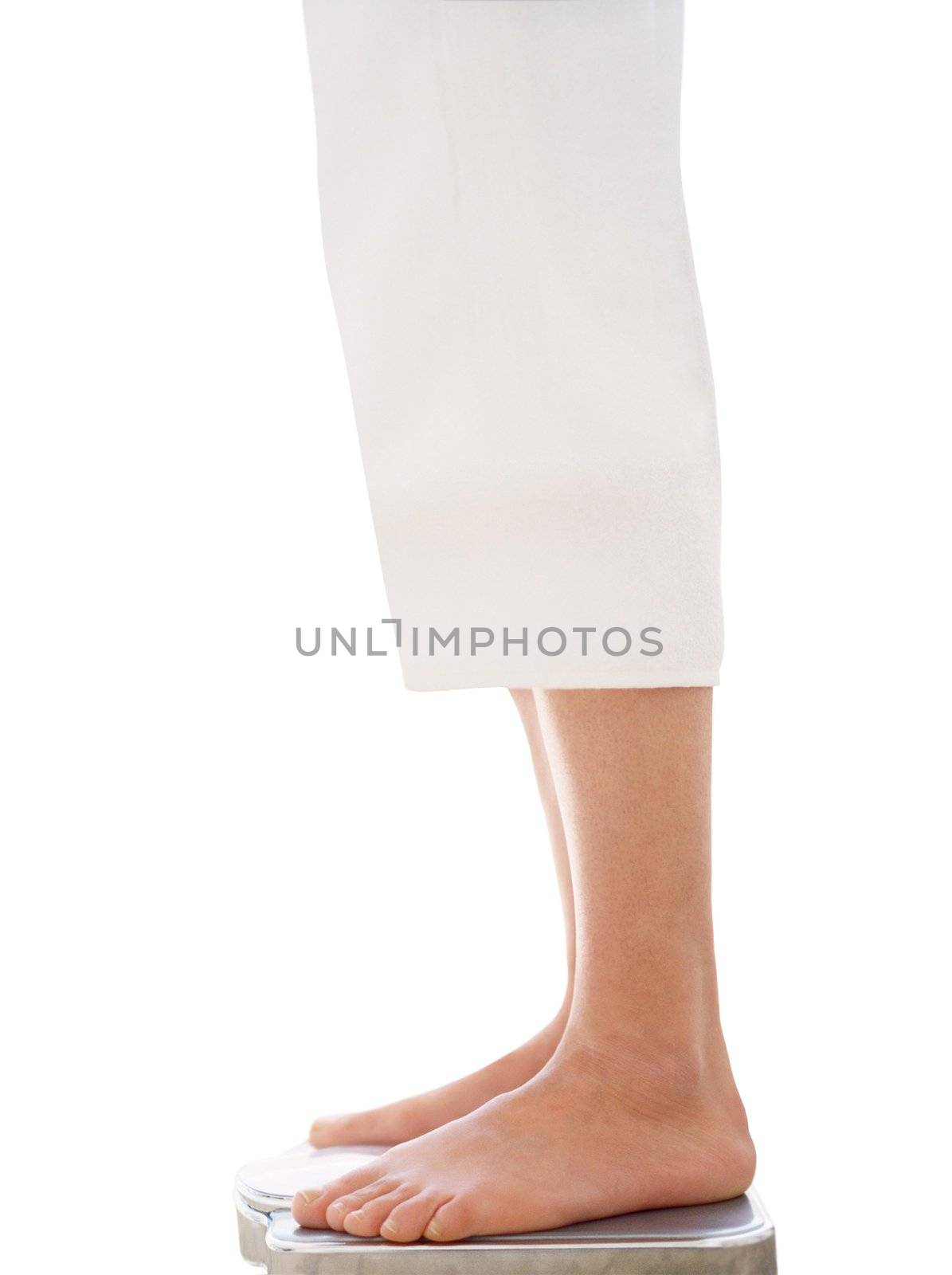 Bare female feet standing on bathroom scale