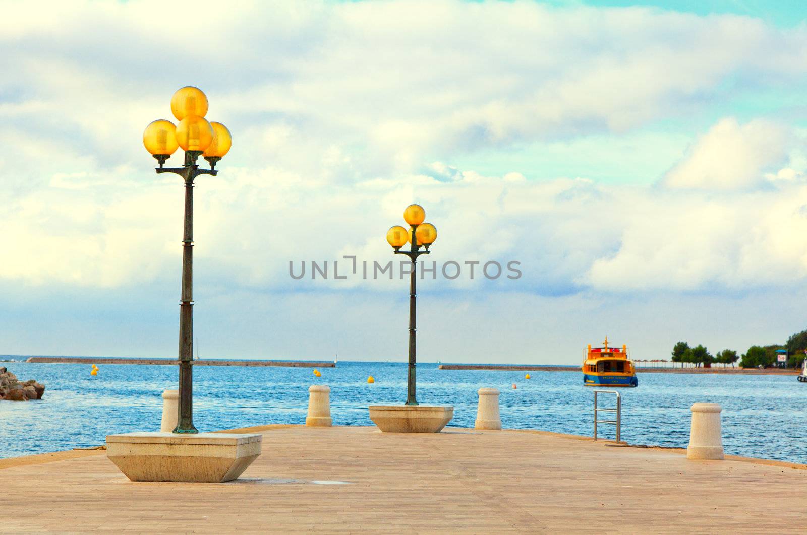 wooden berth with street-lamp on sea background. Pula Croatia