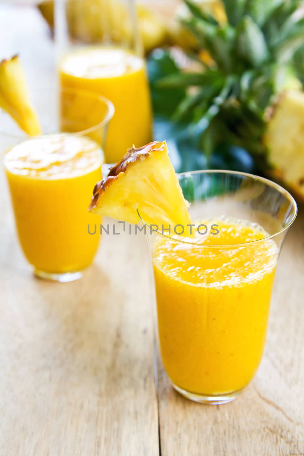 Mango with pineapple smoothie in jug and glasses