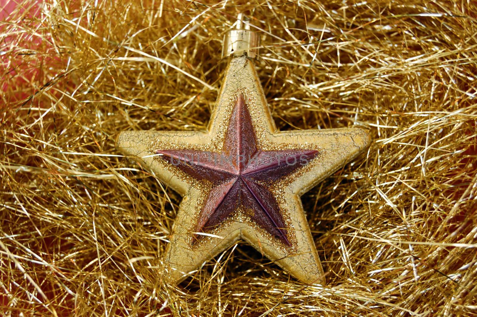 Christmas star bauble on golden background. Seasonal decoration.