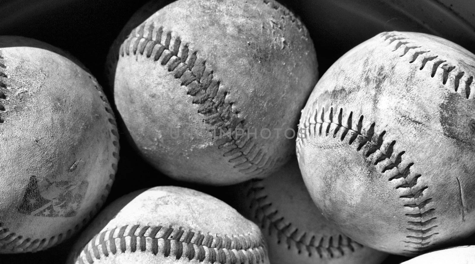 old baseballs in a bucket after a long season