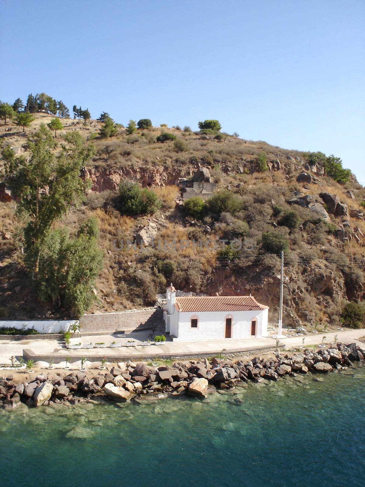 Little church at Poros island near sea water                             