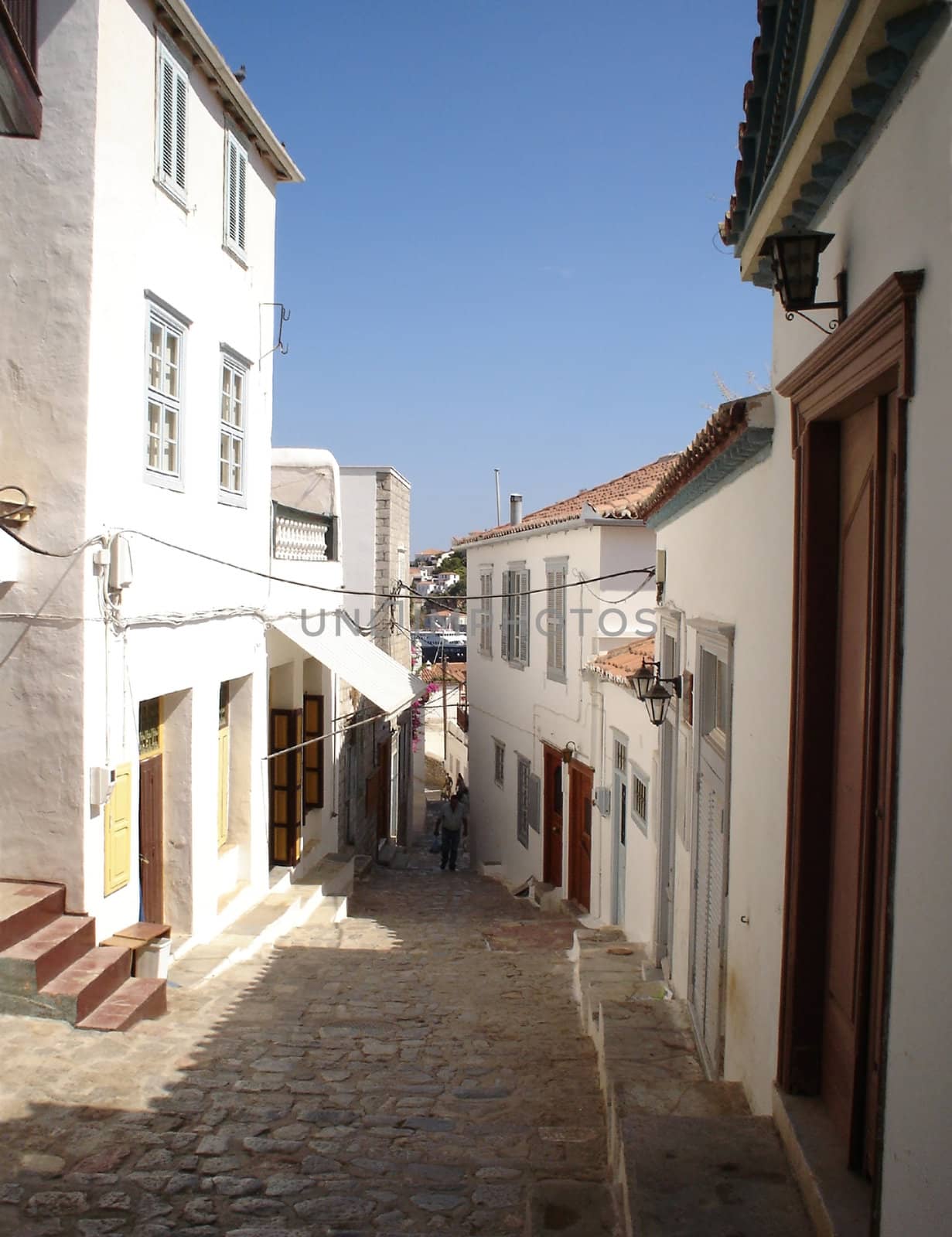 Street of a greek town run down to sea                               