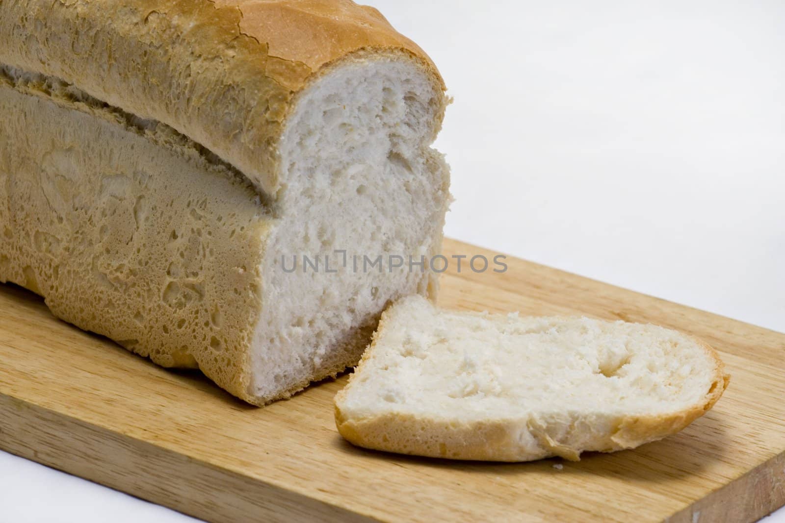 A fresh cut loaf on a wooden board